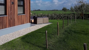 Une maison moderne avec une façade en bois, de grandes fenêtres et un toit de chaume.