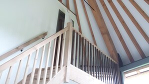 Un plafond en bois orné d’un motif radial et un escalier avec une rampe en bois.