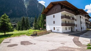 A two-story building with balconies, labeled "Cesa Valeria," set against a mountainous backdrop.