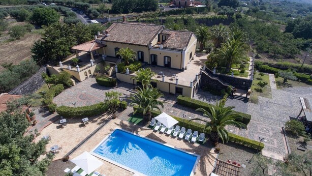 A large villa with a swimming pool, surrounded by lush greenery and palm trees. - Exclusive Villa with Private Pool and Etna View (Piedimonte Etneo)