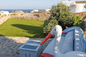 Une sculpture représentant un cygne blanc, avec un bec rouge et un bateau aux couleurs bleue et blanche.