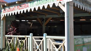 A restaurant with a sign reading "RESTAURANT PIZZERIA IT JARDIN".