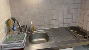 A kitchen with a sink, two stovetops, and a dish rack. - Mayero: Belfond Apartment (Sainte-Anne)