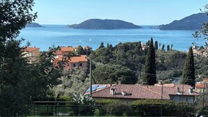 A tennis court with a clear view of the sea and surrounding buildings. - Ulivi House: Parking, Pool, Tennis, 2 AC BDR, 2BTH, + Free Garage in Lerici LTZ! (Lerici)