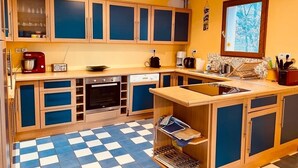Una cocina con armarios de madera, piso a cuadros, horno empotrado y ventana con vistas.