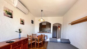 A compact living space with a kitchenette, a dining area, and a sofa. - 0168-POBLAT TIPIC Studio near the beach (Empuriabrava)