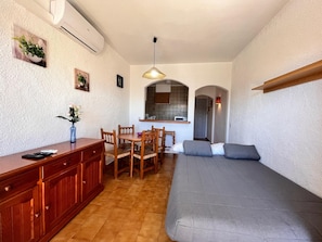 A compact living space with a kitchenette, a dining area, and a sofa. - 0168-POBLAT TIPIC Studio near the beach (Empuriabrava)