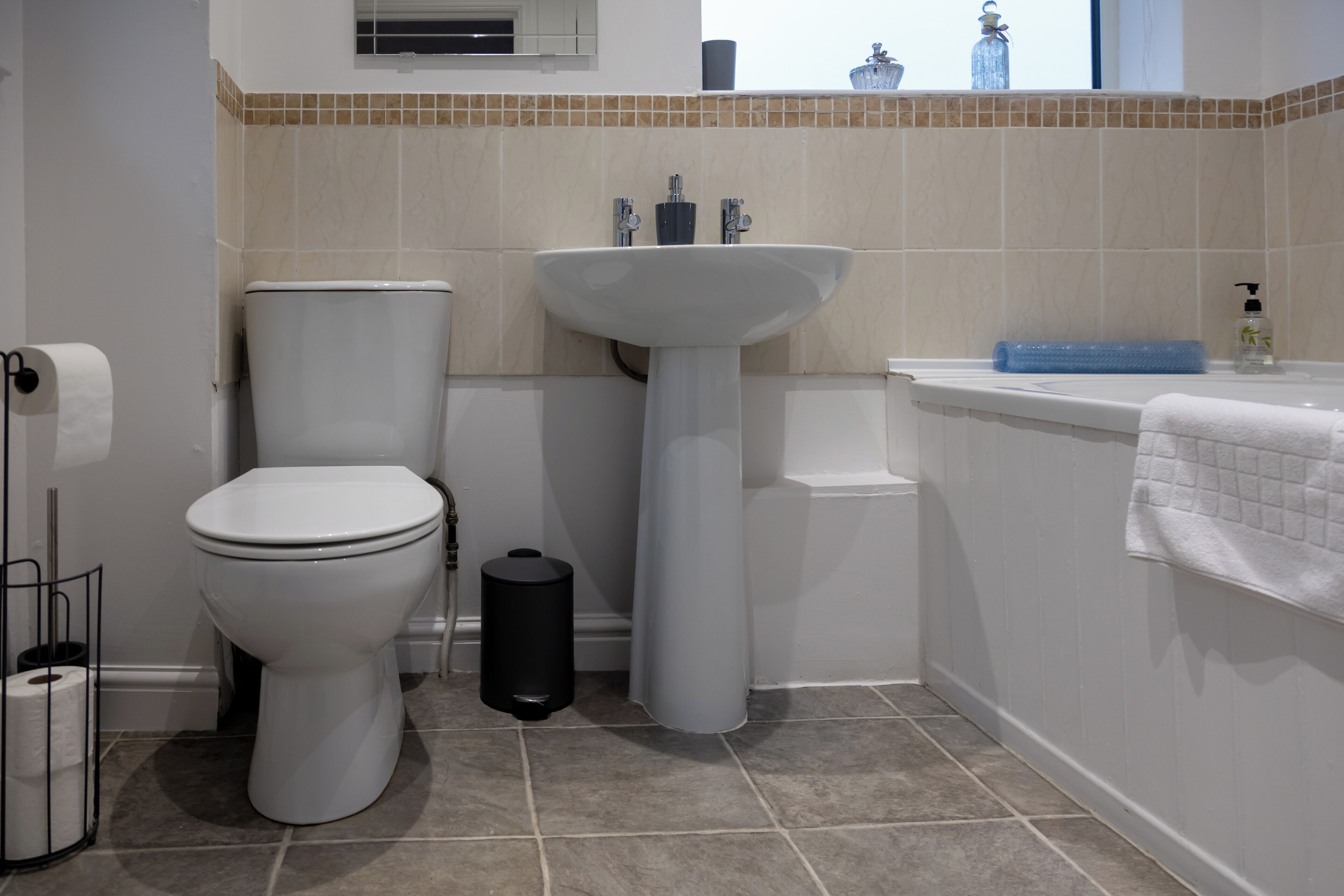 Une salle de bain avec des toilettes, un lavabo et une baignoire.