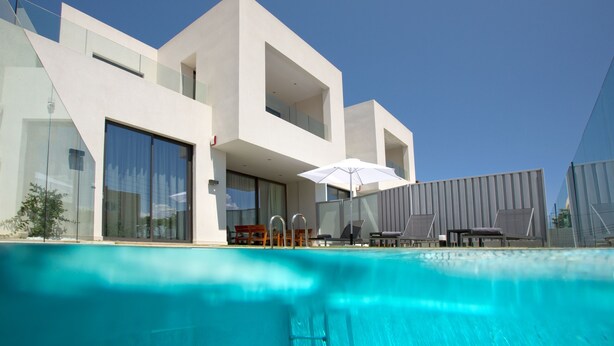 Un hotel modern amb piscina, terrassa exterior i grans finestres.