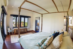 A four-poster bed with a view of the outdoors, a bench, and a chair in a room with wooden beams and large windows. - Canggu Villa & Cooking Retreat (Tibubeneng)