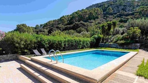 A rectangular pool with steps leading up to it, surrounded by a stone deck and lush greenery. - Can Bajoca 2 , beautiful peaceful surroundings (Pollensa)