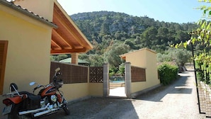 A building with a covered entrance, a parked motorcycle, and a view of a mountainous landscape. - Can Bajoca 2 , beautiful peaceful surroundings (Pollensa)