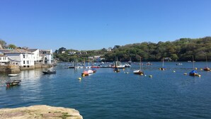 Un port avec des bateaux, une côte rocheuse et des bâtiments en arrière-plan.