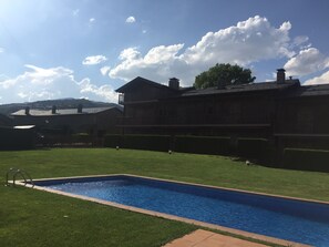A large building with a swimming pool, surrounded by well-maintained grass and a clear sky. - Cozy first floor, with pool and spectacular views in Olopte (La Solana) (olopte (Isovol))