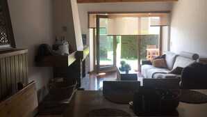 Una sala de estar acogedora con chimenea, un sofá y un comedor con mesa.
