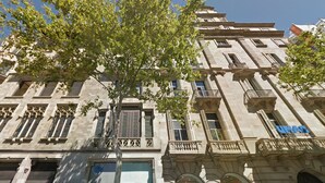 A historic building with ornate architectural details, including arched windows and decorative balconies.