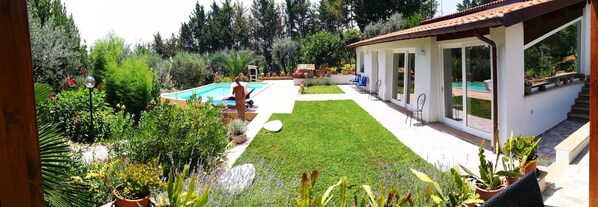Relax by the pool surrounded by lush greenery and enjoy the views from the patio area.