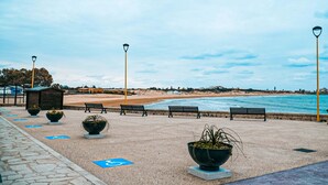 Une promenade en bord de mer, agrémentée de bancs, de lampadaires et de chemins accessibles aux personnes en fauteuil roulant.