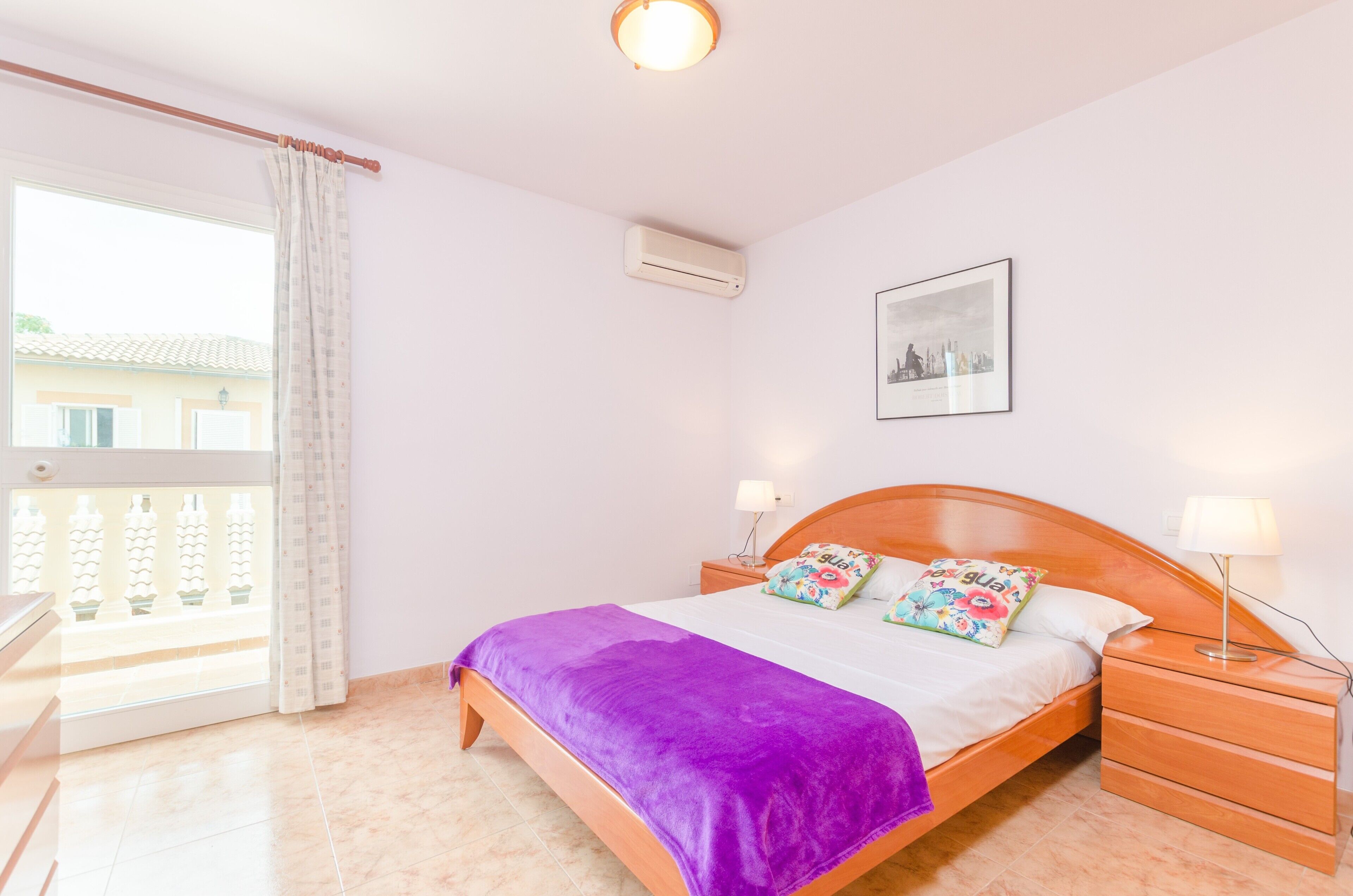 Camera da letto con un letto, comodini, una finestra e un condizionatore.