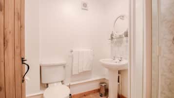 A small, clean bathroom with a toilet, sink, and shower.