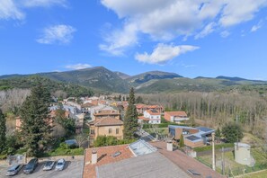 A residential area with houses, a parking lot, and mountains in the background. - Apartament La Foradada (Gualba)