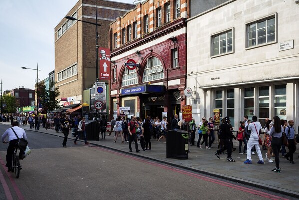A busy street with pedestrians, a KFC sign, and a Camden Town Station sign.
