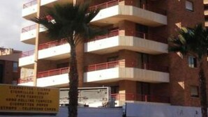 Un immeuble à plusieurs étages doté de balcons, qui pourrait être un hôtel ou un ensemble d’appartements.