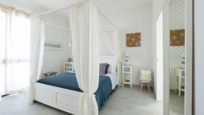 Une chambre à coucher avec un lit à baldaquin, des tables de chevet, une petite table et un miroir.