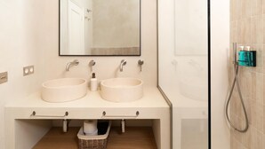 Ein Badezimmer mit zwei Waschbecken, einem Spiegel und einer Dusche.