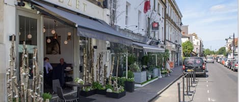 Vista de la calle de un edificio con un restaurante llamado 'MEZZET' en la planta baja.