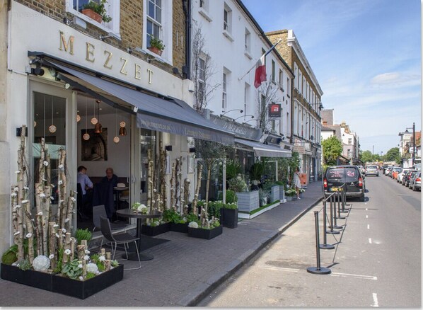A street view of a building with a restaurant named 'MEZZET' on the ground floor.
