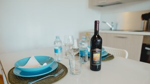 Ein Tisch gedeckt mit blauen Tellern, einer Weinflasche und Wasserflaschen.