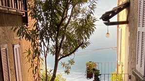 A narrow stairway leading to a balcony with potted plants and a view of the sea. - Fantastic apartment with a wonderful panoramic view of Lake Como  (Dorio)