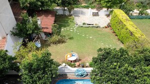 A backyard with a swimming pool, a hammock, and a small deck area. - VILLA SOFIA (ground floor self - contained apartment) (Marathos)