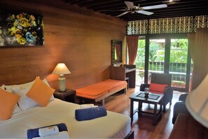 Habitación de hotel con cama, escritorio, silla y vistas a zonas verdes.