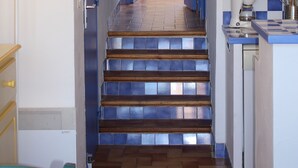 A staircase leading to a kitchen with blue accents, a window, and a sink. - Gites de France Blue by the sea. Free WIFI. (Port-La-Nouvelle)