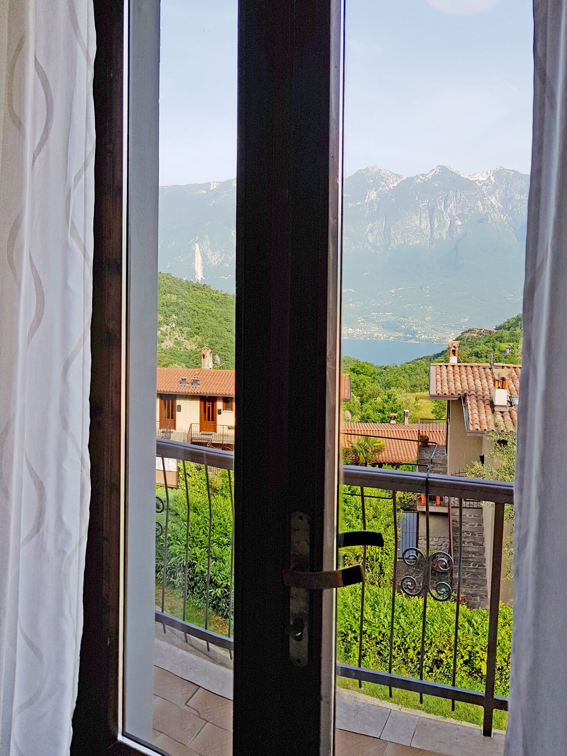 A balcony with a view of a mountainous landscape and a lake.