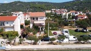 A coastal residential area with houses, a marina, and a clear view of the sea.