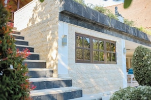 Un bâtiment en pierre avec une fenêtre et une statue sur le toit.