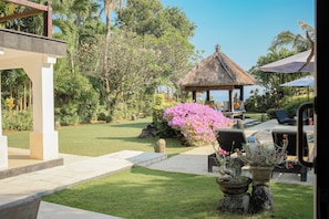 Un jardin bien entretenu, agrémenté d’un belvédère, d’un espace salon extérieur et d’un coin piscine.