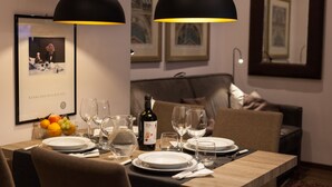 A dining area with a table set for two, featuring a bottle of wine, glasses, and a bowl of fruit. - Rome Boutique Apartments, seductive, close on foot to the vatican and the center (6900334)
