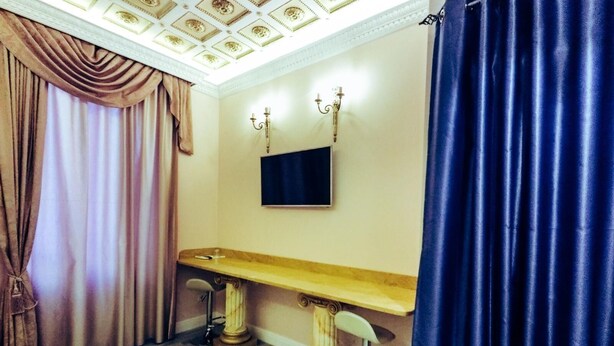 A room with a wooden bench, a flat-screen TV mounted on the wall, and a large window with curtains. - Queen Suite (Vatican St. Peter's) (Roma)