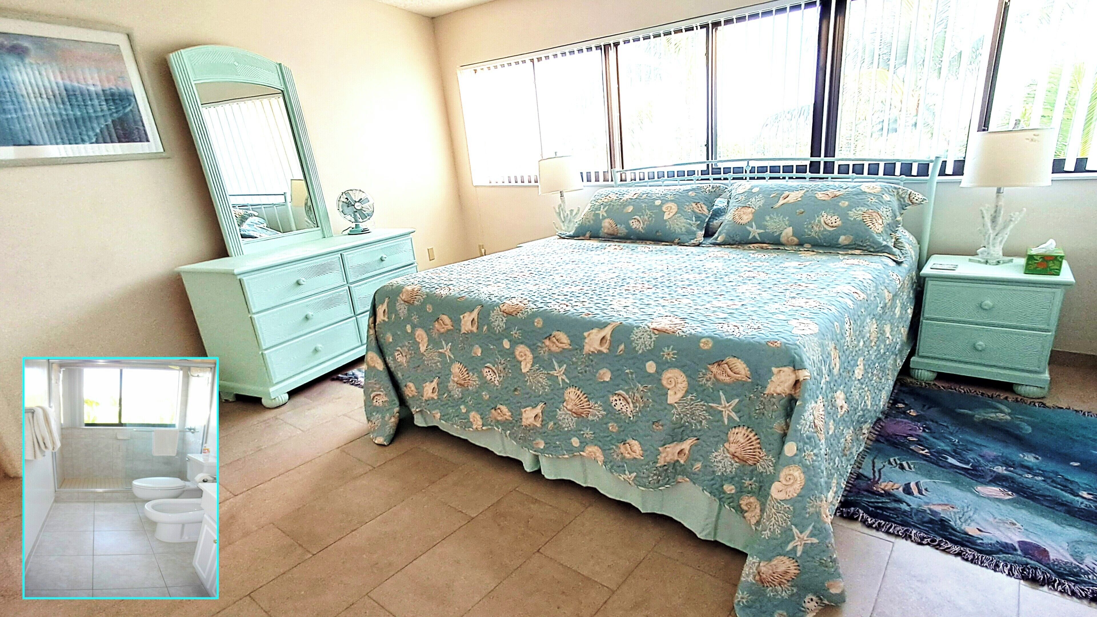 A bedroom with a bed, a dresser, a nightstand, a mirror, and a window with blinds.