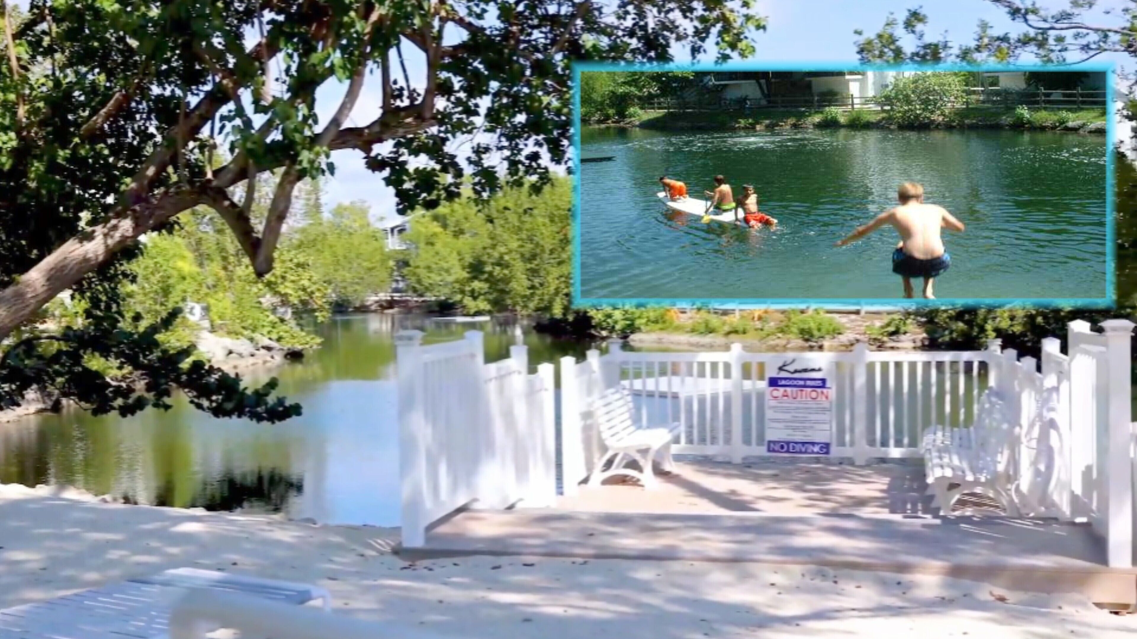A lake with a white fence and a sign indicating no diving.