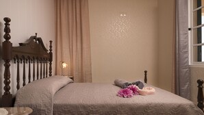A neatly made bed with a headboard, a bedside lamp, and decorative pillows. - Viewpoint House (Ponta Sol)