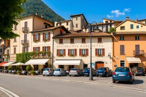 A restaurant named 'RISTORANTE BARCHETTA' with outdoor seating and parked cars.