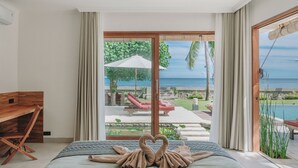 Una camera da letto con un letto, una scrivania in legno e vista su una piscina e un'area relax all'aperto.