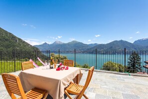 A table set outdoors with a mountain view, a lake, and a clear sky.