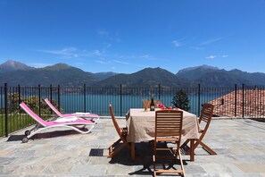 A terrace with a table set for two, overlooking a lake and mountains. - Parco dei Cervi Terrazzo, Plesio, Italy (Plesio)