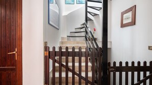 A staircase with a wooden railing, a wooden door, and a framed picture on the wall. - Domus Sicily - Il nido di suerte sea view (Palermo)